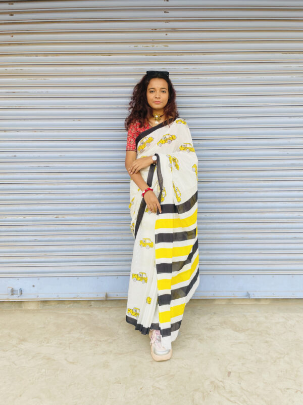 White Mulmul Saree featuring yellow taxi print and bold striped pallu.